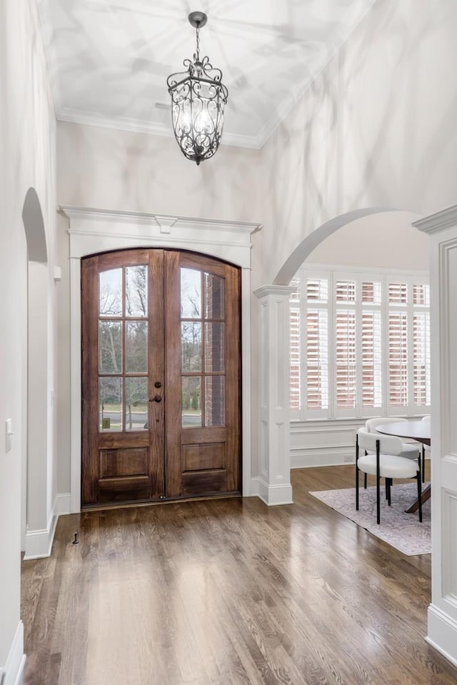 entrance foyer with arched walkways, wood finished floors, and french doors