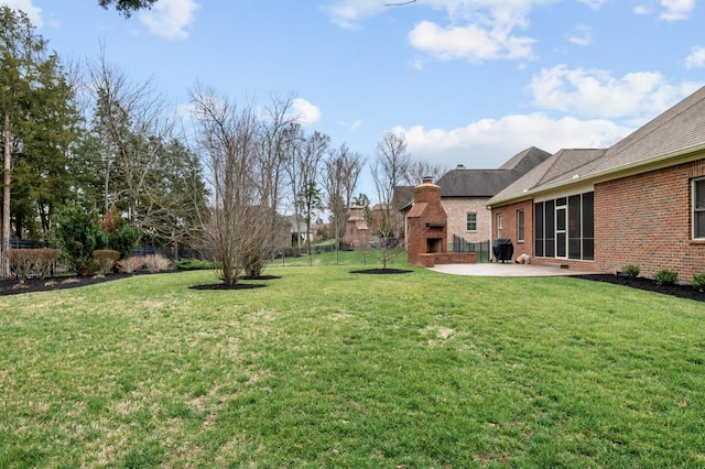 view of yard with a patio, exterior fireplace, and fence