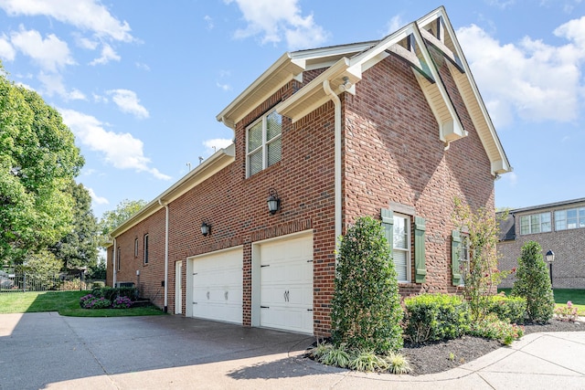 view of home's exterior with concrete driveway, brick siding, and an attached garage