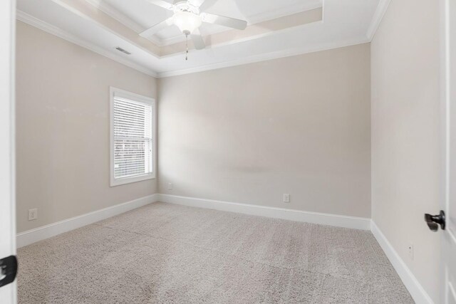 unfurnished room with visible vents, baseboards, ornamental molding, a tray ceiling, and carpet