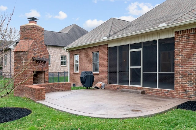 view of patio featuring an outdoor brick fireplace, a sunroom, and a grill