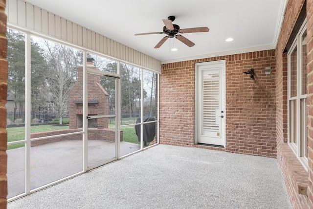 unfurnished sunroom featuring ceiling fan