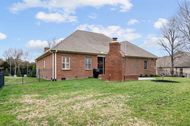 rear view of property with brick siding, a chimney, fence, and a lawn