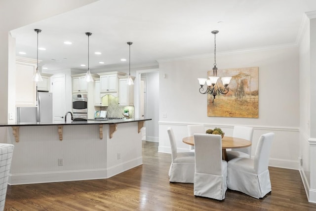 kitchen with dark countertops, dark wood-style floors, a breakfast bar, and stainless steel appliances