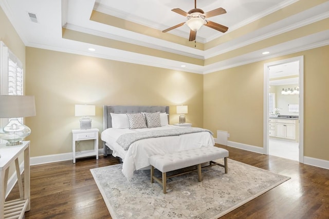 bedroom with baseboards, crown molding, a tray ceiling, and dark wood-style flooring