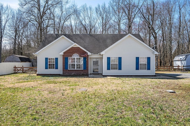 single story home with brick siding, fence, and a front yard