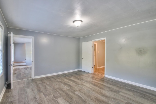 empty room featuring wood finished floors and baseboards