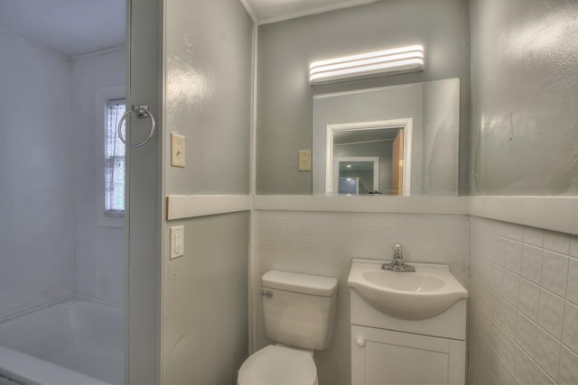 full bathroom with toilet, a bath, vanity, and tile walls