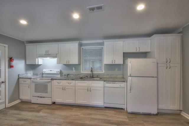 kitchen featuring white appliances, visible vents, white cabinets, under cabinet range hood, and a sink