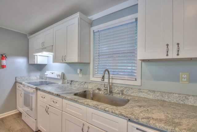 kitchen with white appliances, under cabinet range hood, white cabinets, and a sink