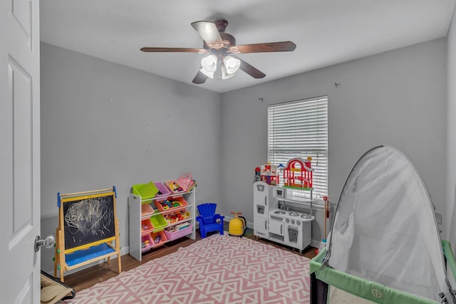 game room with ceiling fan, baseboards, and wood finished floors