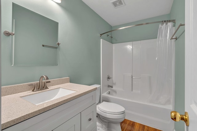 full bath with visible vents, toilet, shower / bath combo with shower curtain, vanity, and wood finished floors