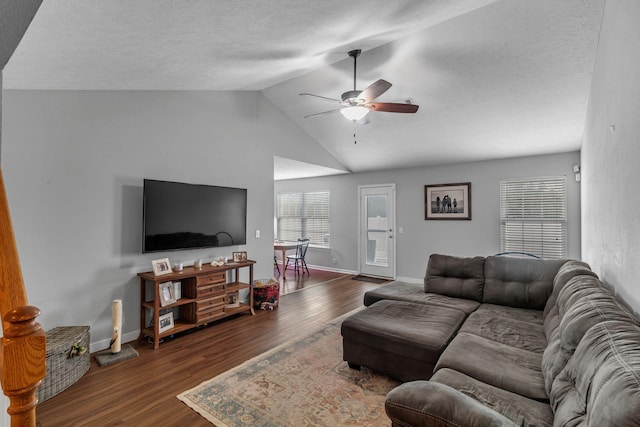 living room with lofted ceiling, dark wood finished floors, a ceiling fan, and baseboards