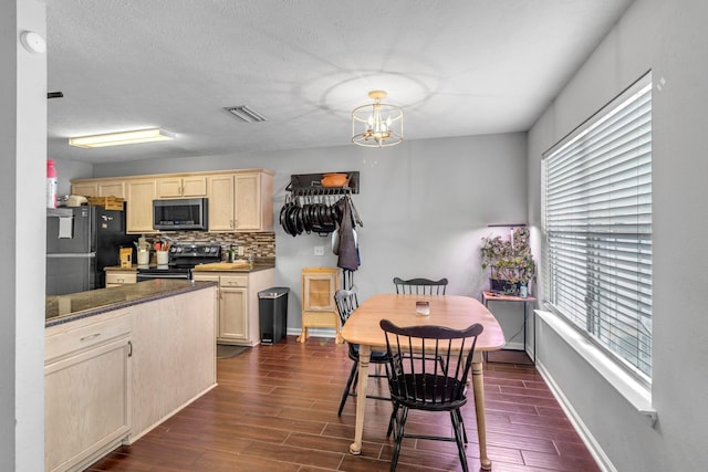 kitchen with stainless steel appliances, visible vents, decorative backsplash, wood tiled floor, and light brown cabinets