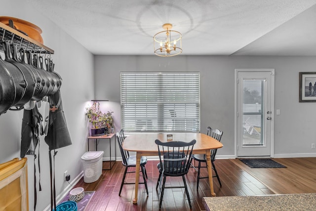 dining area featuring a healthy amount of sunlight, dark wood finished floors, and an inviting chandelier