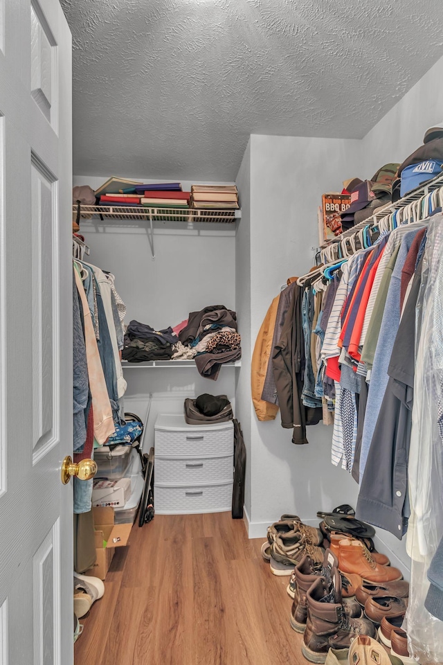 walk in closet with wood finished floors