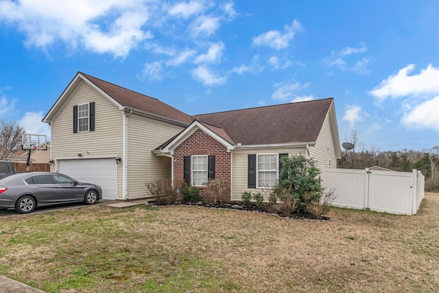 traditional-style house featuring a garage, brick siding, a front lawn, and fence