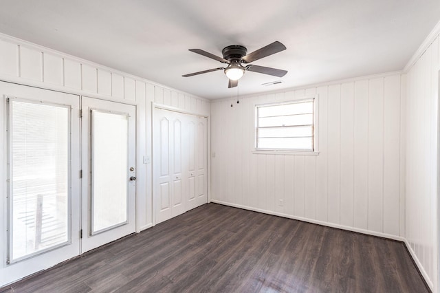 empty room featuring ceiling fan, dark wood-style flooring, and visible vents