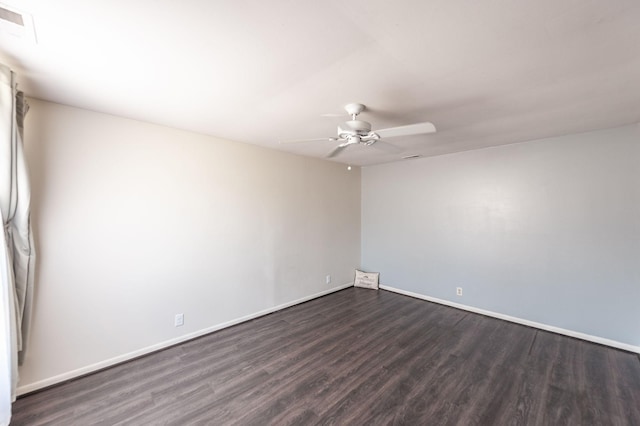 empty room with baseboards, visible vents, a ceiling fan, and dark wood-style flooring