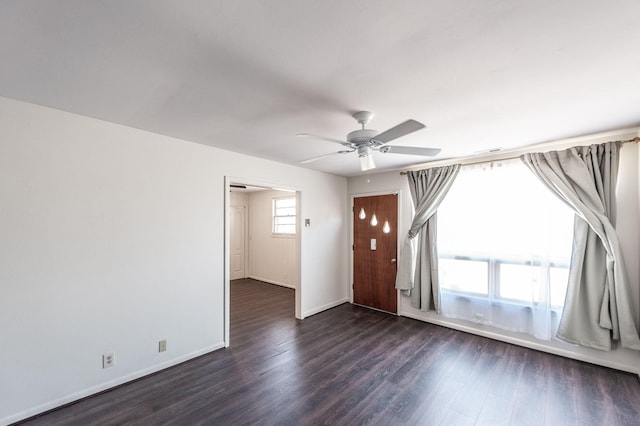 interior space featuring dark wood-type flooring, baseboards, and a ceiling fan