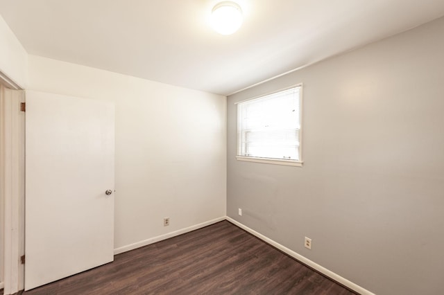 unfurnished room with dark wood-style floors and baseboards