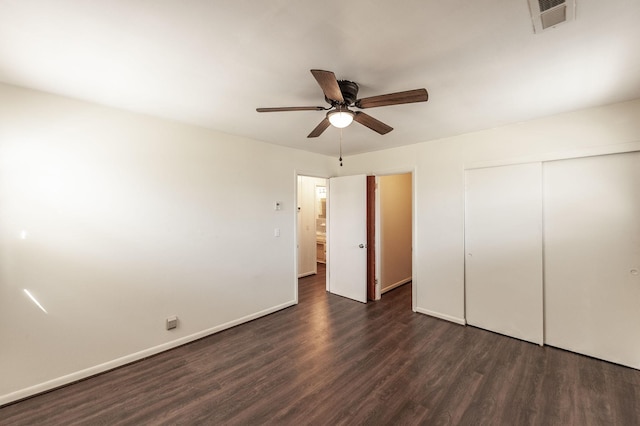 unfurnished bedroom featuring dark wood-style floors, a closet, visible vents, a ceiling fan, and baseboards