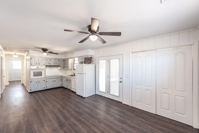 kitchen featuring white appliances, crown molding, light countertops, and dark wood-type flooring