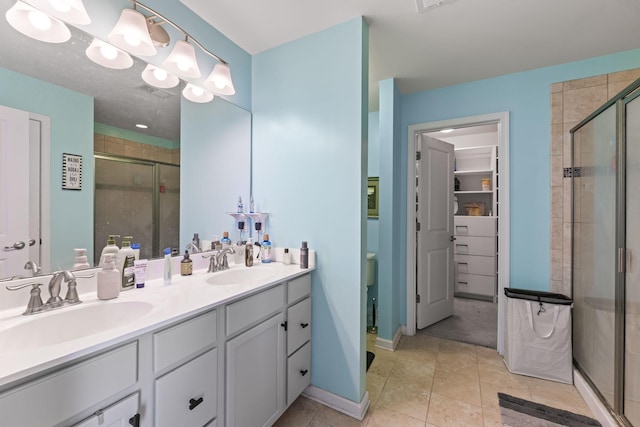 bathroom featuring tile patterned floors, a sink, a shower stall, and double vanity