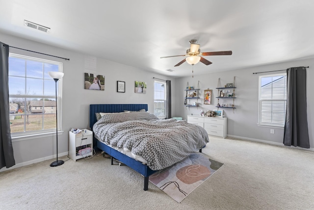 carpeted bedroom with a ceiling fan, visible vents, and baseboards