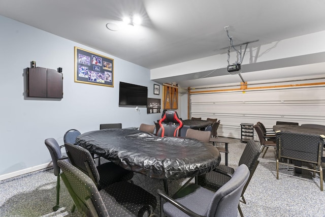 game room with a garage, carpet, and baseboards