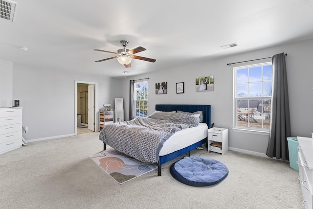 bedroom featuring light carpet, ceiling fan, visible vents, and baseboards