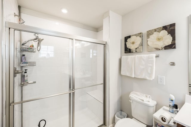 bathroom with a stall shower, vanity, and toilet