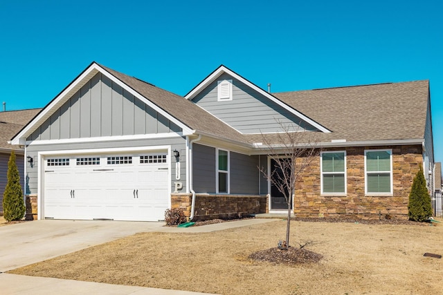 craftsman-style home with a shingled roof, concrete driveway, stone siding, an attached garage, and board and batten siding