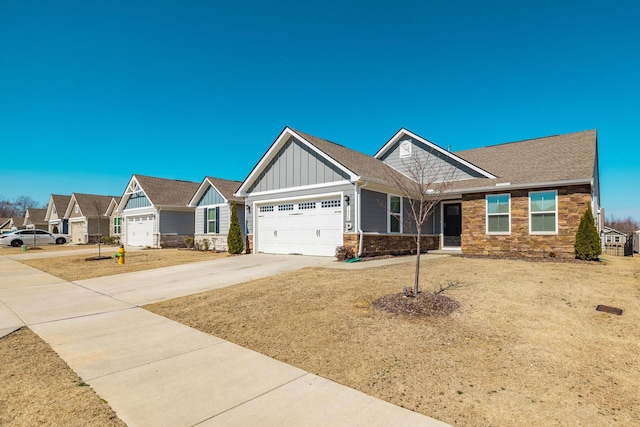 craftsman-style home featuring an attached garage, board and batten siding, a residential view, stone siding, and driveway