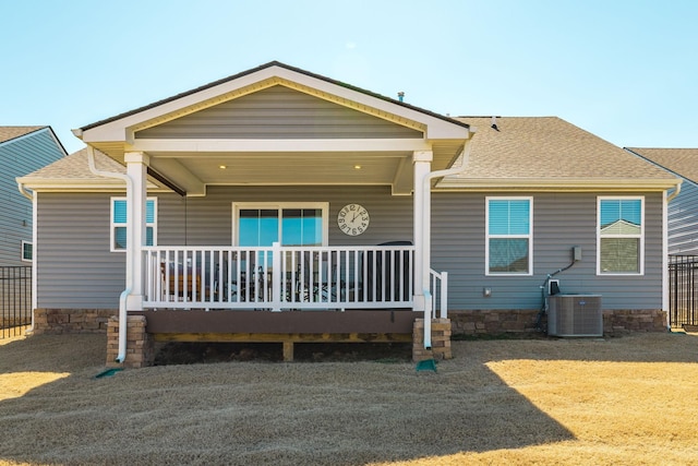 view of front of house with central air condition unit, a porch, and roof with shingles