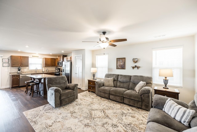 living area featuring recessed lighting, visible vents, dark wood-type flooring, ceiling fan, and baseboards