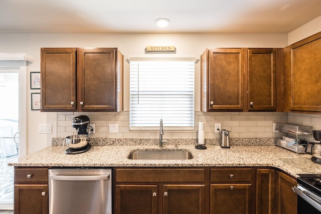 kitchen with light stone counters, range with electric stovetop, decorative backsplash, a sink, and dishwasher