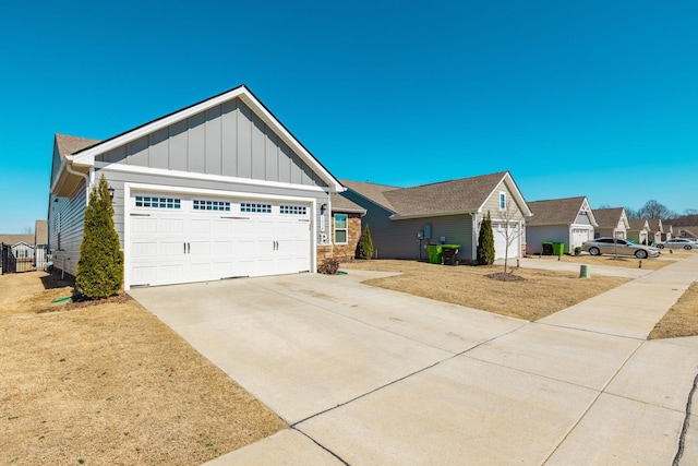 view of front of house with board and batten siding, a residential view, driveway, and an attached garage