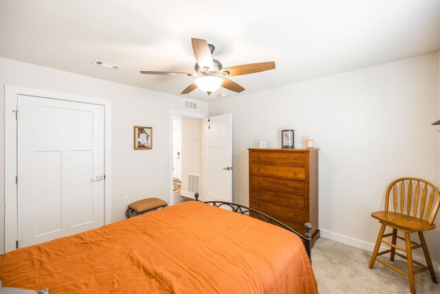 carpeted bedroom with a ceiling fan, visible vents, and baseboards