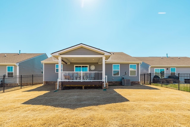 rear view of house featuring covered porch, a fenced backyard, central AC unit, and a yard