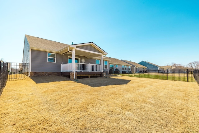 rear view of house with a fenced backyard, a yard, and a wooden deck