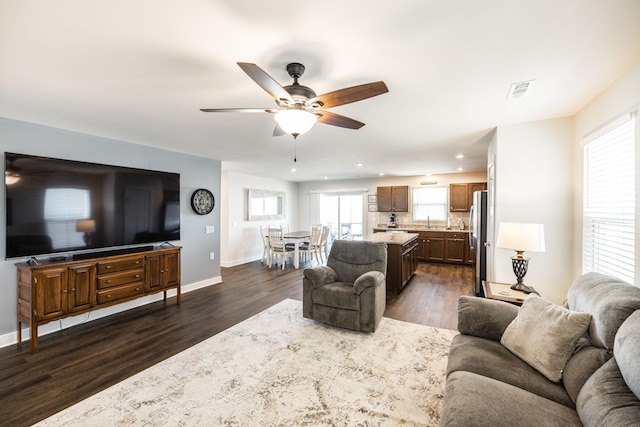 living area featuring recessed lighting, visible vents, a ceiling fan, baseboards, and dark wood-style floors