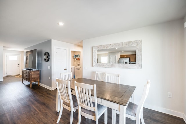 dining area featuring washer / clothes dryer, dark wood-style flooring, and baseboards