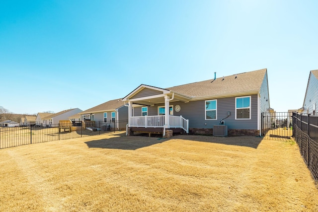 rear view of property with a fenced backyard, a yard, and central AC unit