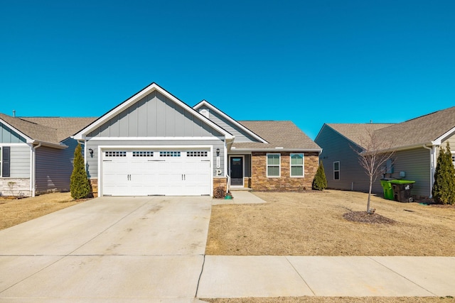 craftsman inspired home featuring board and batten siding, concrete driveway, stone siding, and an attached garage