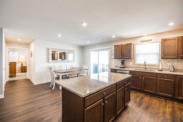 kitchen with dark wood-style flooring, visible vents, a sink, and decorative backsplash