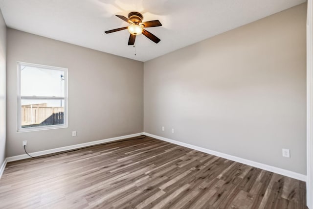 spare room with ceiling fan, baseboards, and wood finished floors