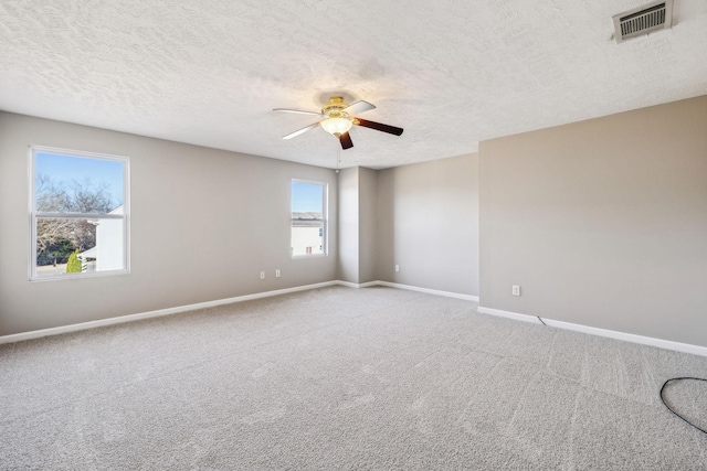 spare room with baseboards, visible vents, ceiling fan, a textured ceiling, and carpet floors