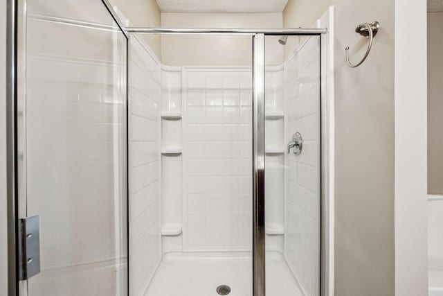 full bath with a stall shower and a textured ceiling