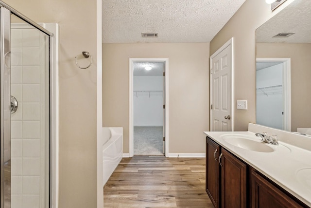 full bath with a bath, a stall shower, a sink, and visible vents